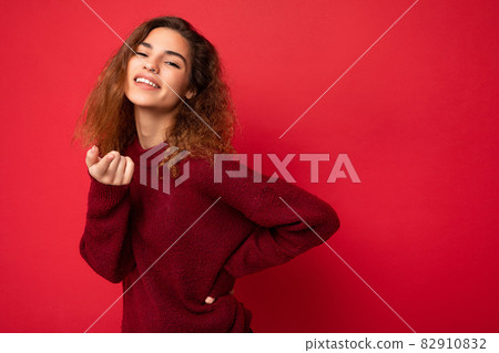 Portrait of young positive happy attractive brunette curly woman with sincere emotions wearing 82910832