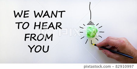 Support symbol. Businessman writing 'we want to hear from you', isolated on beautiful white background. Light bulb icon. Business and support concept. Copy space. 82910997