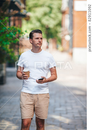 Young man drinking coffee in the city outdoors Young man drinking coffee in the city outdoors 82911092