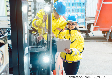 Forklift driver and forewoman discussing where to store delivery Forklift driver and forewoman discussing where to store delivery 82911435
