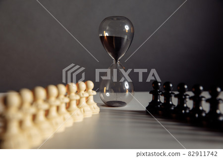 Hourglass and chess pieces. Sports and leisure concept. 82911742
