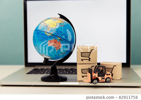Globe with boxes on a laptop. Online shopping and delivery concept 82911758