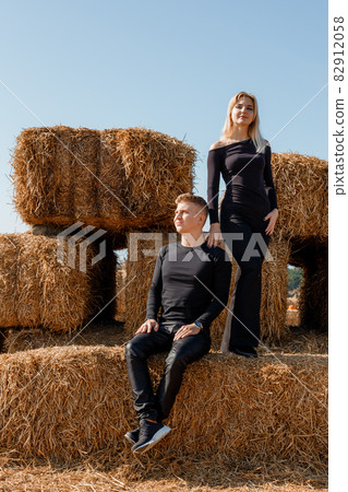 Happy family sitting on hay bales. outdoor market. Autumn time. 82912058