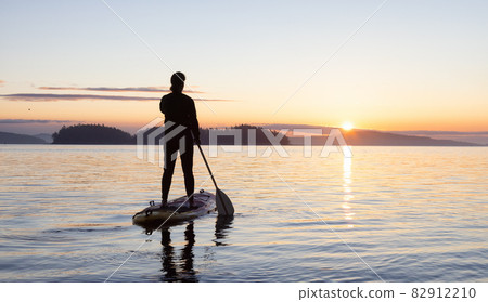 Adventurous Caucasian Adult Woman on a Stand Up Paddle Board Adventurous Caucasian Adult Woman on a Stand Up Paddle Board 82912210