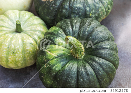 Autumnal Background. Natural autumn fall view pumpkins on dark black stone shale background, October or september wallpaper Change of seasons ripe organic food concept Halloween party Thanksgiving day Autumnal Background. Natural autumn fall view pumpkins on dark black stone shale background, October or september wallpaper Change of seasons ripe organic food concept Halloween party Thanksgiving day 82912378