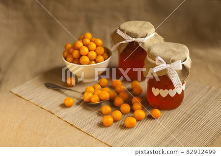 cherry plums yellow Jam, fresh berries fruits. homemade marmalade in glass jar on brown textile background 82912499