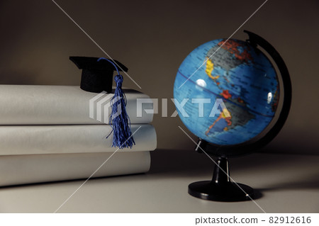 Graduated student studying abroad international idea. Graduation hat and globe on a table Graduated student studying abroad international idea. Graduation hat and globe on a table 82912616