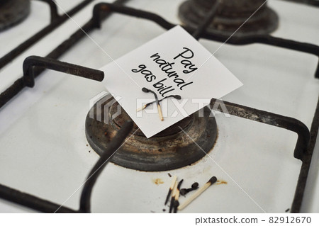 An old and grungy gas stove with no gas and piece of paper with text - No gas 82912670