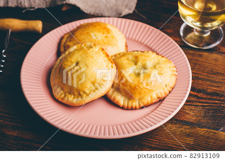 Baked Hand Pies with Chives and Mushrooms on Plate with Glass of Wine Baked Hand Pies with Chives and Mushrooms on Plate with Glass of Wine 82913109