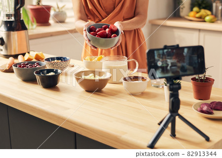 Young housewife giving masterclass of cooking smoothie Young housewife giving masterclass of cooking smoothie 82913344
