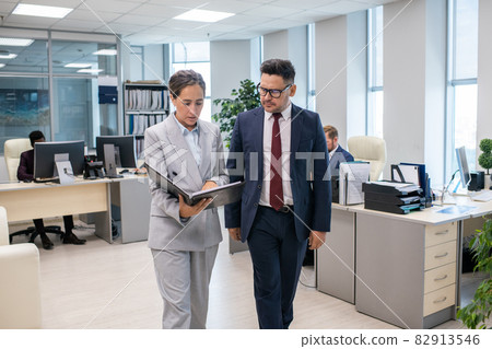 Two elegant employees discussing new contract held by female 82913546