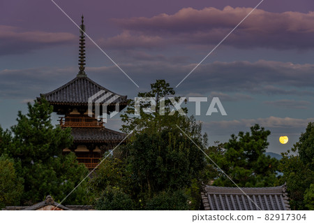 Ikaruga Town, Nara Prefecture, a harvest moon rising from the other side of the three-storied pagoda of Hokiji Temple, a World Heritage Site Ikaruga Town, Nara Prefecture, a harvest moon rising from the other side of the three-storied pagoda of Hokiji Temple, a World Heritage Site 82917304