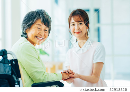 Elderly and young care workers in wheelchairs Elderly and young care workers in wheelchairs 82918826