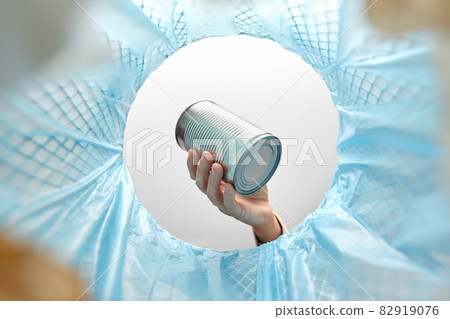 hand throwing tin can into rubbish bin hand throwing tin can into rubbish bin 82919076