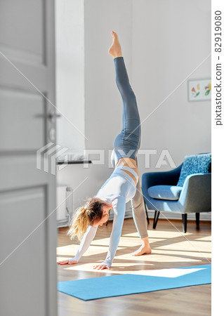 woman doing yoga exercise on window sill at studio 82919080