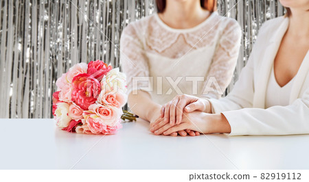 close up of happy lesbian couple with flowers 82919112