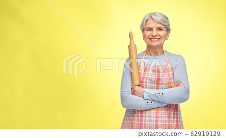 smiling senior woman in apron with rolling pin smiling senior woman in apron with rolling pin 82919129