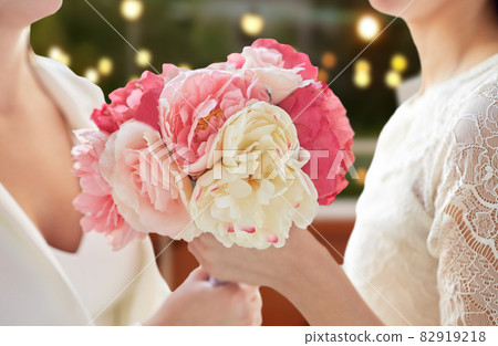 close up of lesbian couple with flowers at party close up of lesbian couple with flowers at party 82919218