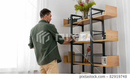 man decorating home and arranging shelf 82919748