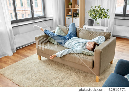 young man sleeping on sofa at home young man sleeping on sofa at home 82919771