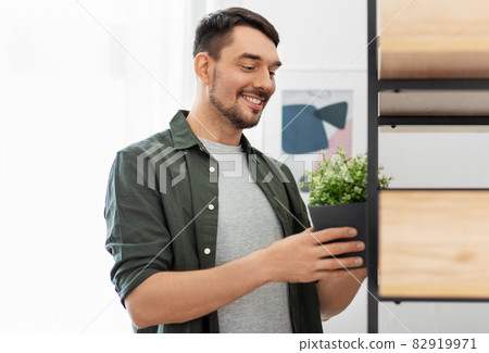 man decorating home with flower or houseplant 82919971