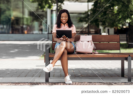 african american woman with tablet pc in city 82920073