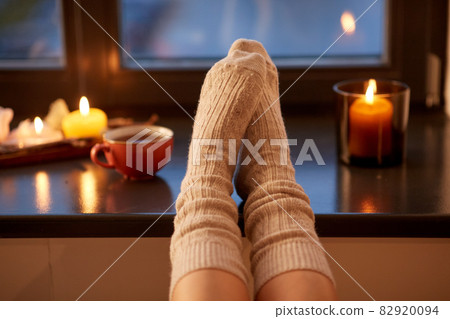 legs in socks on window sill at home in autumn legs in socks on window sill at home in autumn 82920094