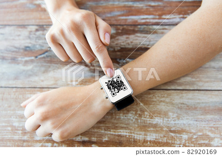 woman's hands with qr code on smart watch 82920169