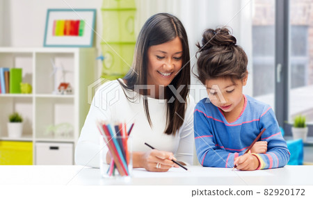 happy mother and daughter drawing at home 82920172