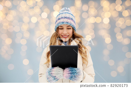 woman with tablet computer outdoors in winter 82920173