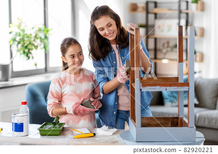 mother and daughter sanding old table with sponge mother and daughter sanding old table with sponge 82920221