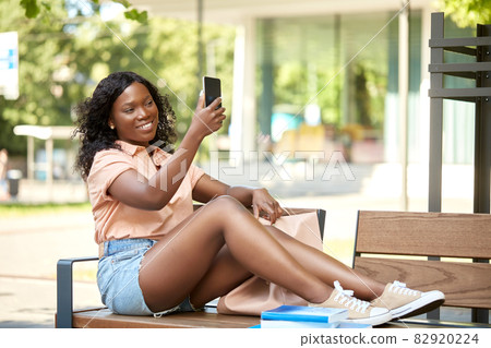 african student girl taking selfie with smartphone african student girl taking selfie with smartphone 82920224