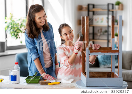 mother and daughter sanding old table with sponge mother and daughter sanding old table with sponge 82920227