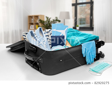 travel bag packed with clothes, gloves and masks travel bag packed with clothes, gloves and masks 82920275