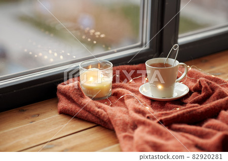 cup of tea and candle on window sill cup of tea and candle on window sill 82920281