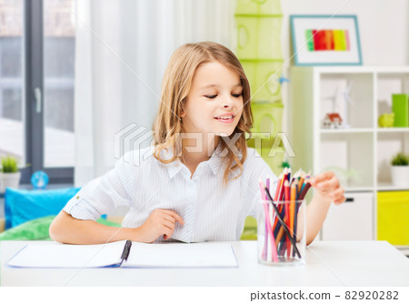happy girl drawing with pencils at home happy girl drawing with pencils at home 82920282
