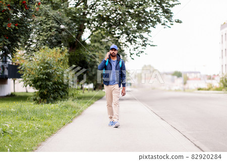 indian delivery man with bag calling on smartphone indian delivery man with bag calling on smartphone 82920284