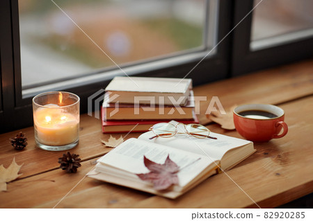 book, coffee and candle on window sill in autumn book, coffee and candle on window sill in autumn 82920285
