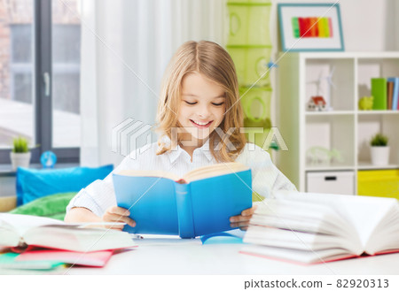 happy smiling student girl reading book at home happy smiling student girl reading book at home 82920313
