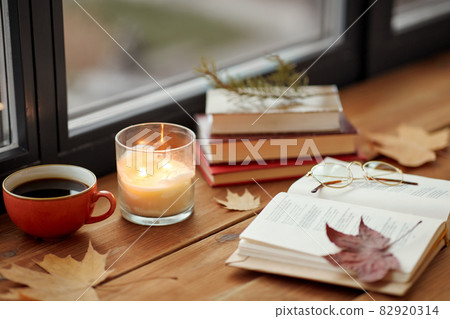 book, coffee and candle on window sill in autumn book, coffee and candle on window sill in autumn 82920314