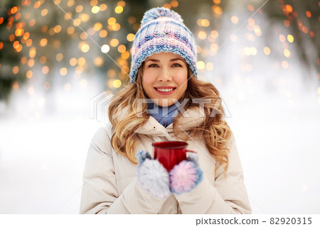 happy young woman with tea cup outdoors in winter happy young woman with tea cup outdoors in winter 82920315