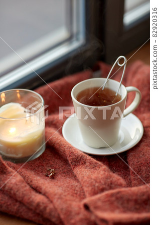 cup of tea and candle on window sill 82920316