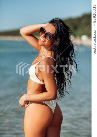 happy young woman in bikini swimsuit on beach happy young woman in bikini swimsuit on beach 82920333