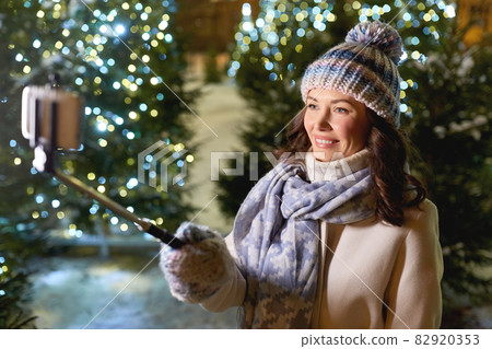 happy woman taking christmas selfie on smartphone happy woman taking christmas selfie on smartphone 82920353