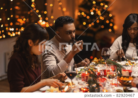 happy friends having christmas dinner at home happy friends having christmas dinner at home 82920467