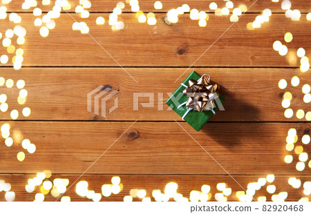 christmas gift on wooden boards over lights 82920468