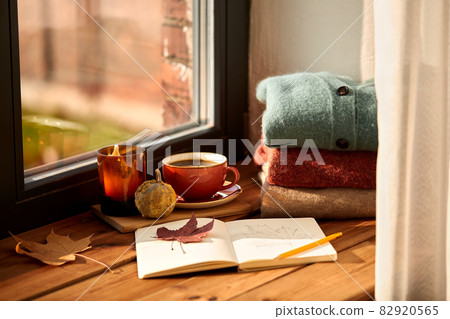 sketchbook, autumn leaf and coffee on window sill 82920565