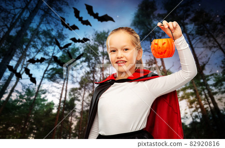 girl in halloween costume of dracula with pumpkin 82920816