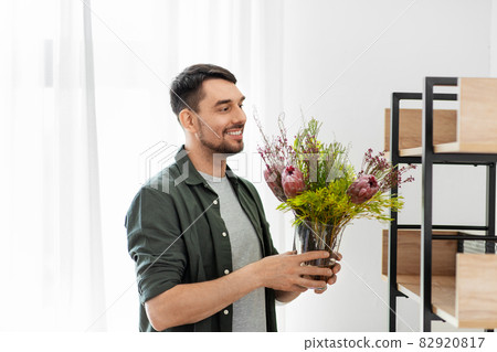 man decorating home with flower or houseplant 82920817