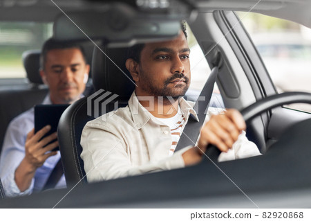 indian male driver driving car with passenger indian male driver driving car with passenger 82920868